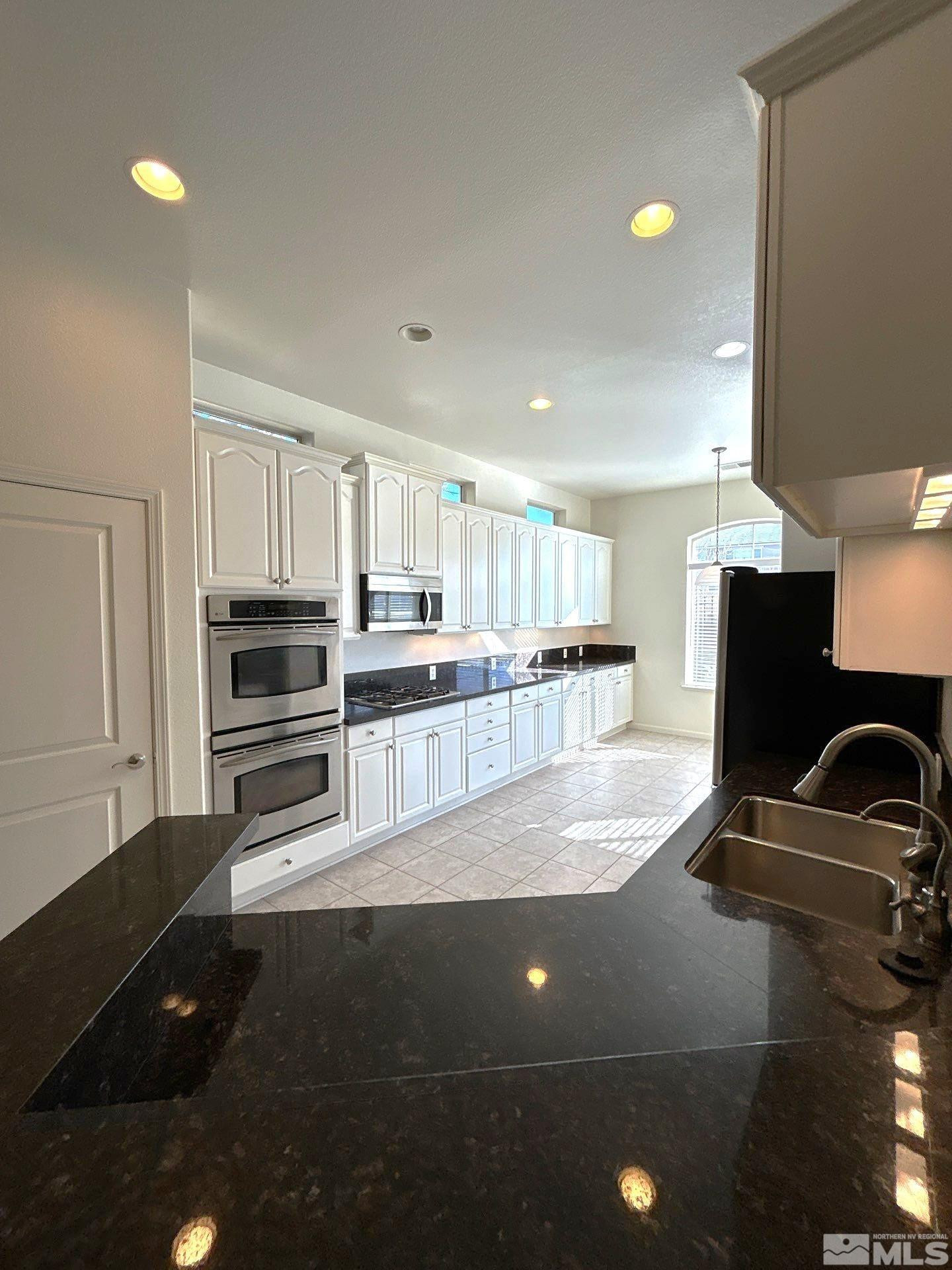 9900 Wilbur May Parkway, Unit 3402 Reno, NV 89521 - Photo 4 of 26 a kitchen with granite countertop a stove and a refrigerator