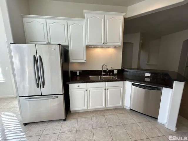 a kitchen with a refrigerator sink and cabinets