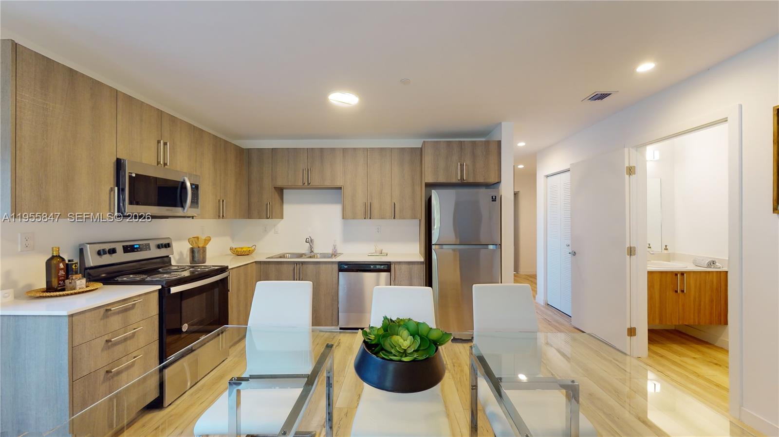 a kitchen with stainless steel appliances a stove a sink a microwave a refrigerator and cabinets