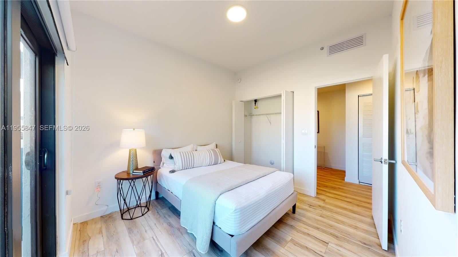 24705 Southwest 129th Avenue, Unit 107 Homestead, FL 33032 - Photo 21 of 33 a bedroom with a bed and a mirror