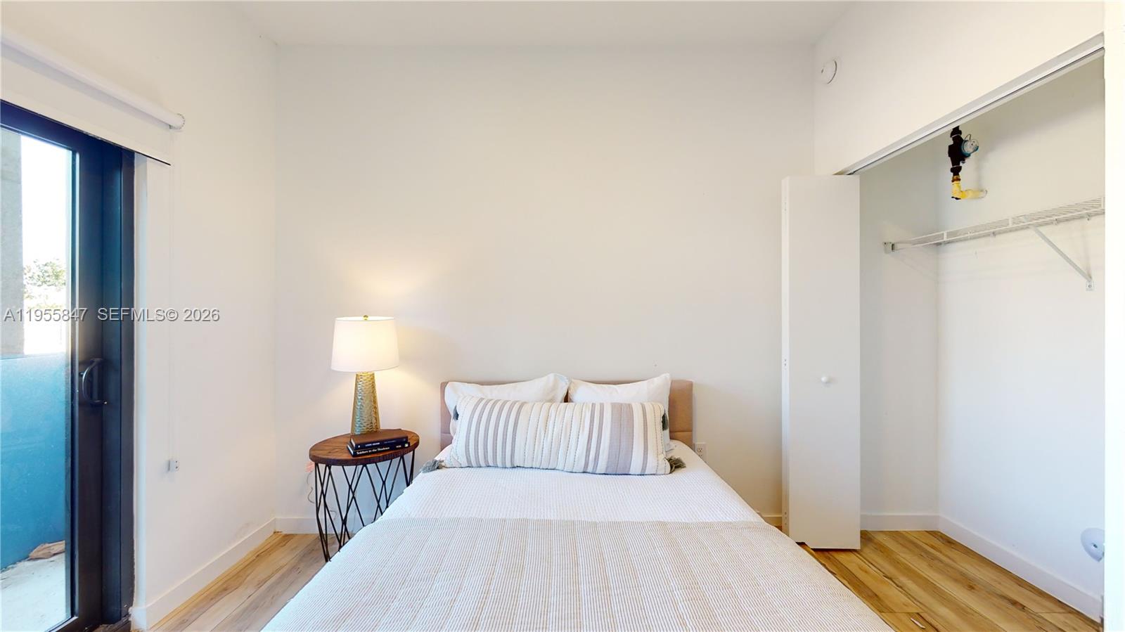 24705 Southwest 129th Avenue, Unit 107 Homestead, FL 33032 - Photo 23 of 33 a bed room with a bed and a lamp