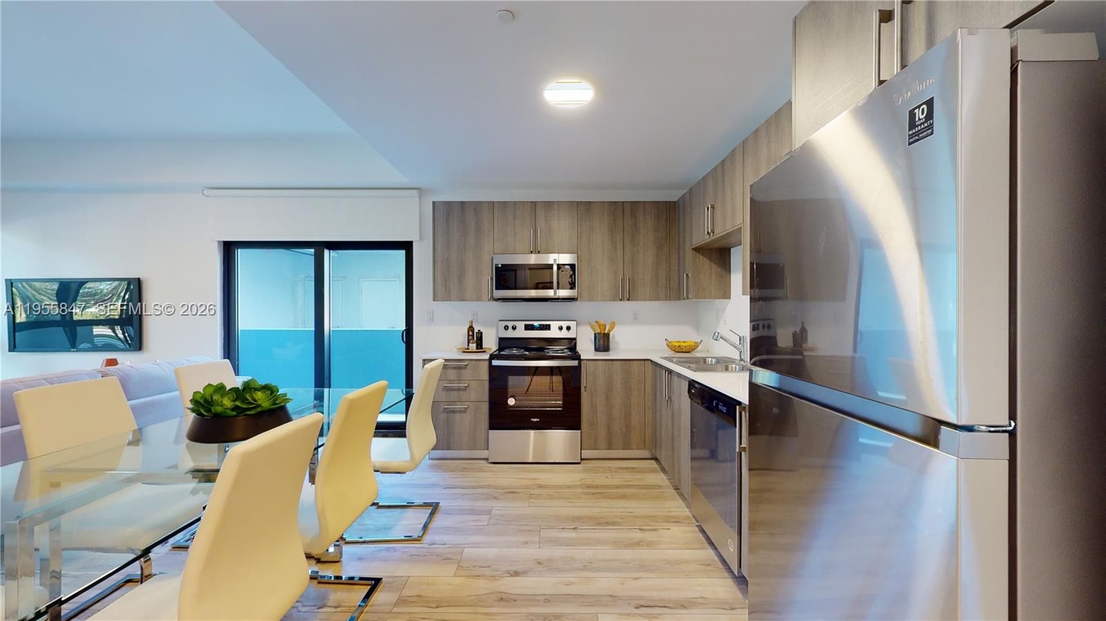 24705 Southwest 129th Avenue, Unit 107 Homestead, FL 33032 - Photo 3 of 33 a kitchen with kitchen island a counter top space a sink stainless steel appliances and cabinets