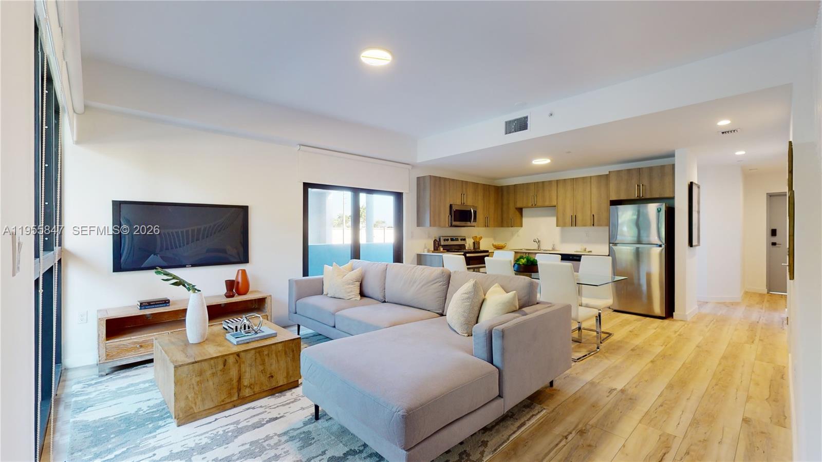 24705 Southwest 129th Avenue, Unit 107 Homestead, FL 33032 - Photo 6 of 33 a living room with furniture and a flat screen tv