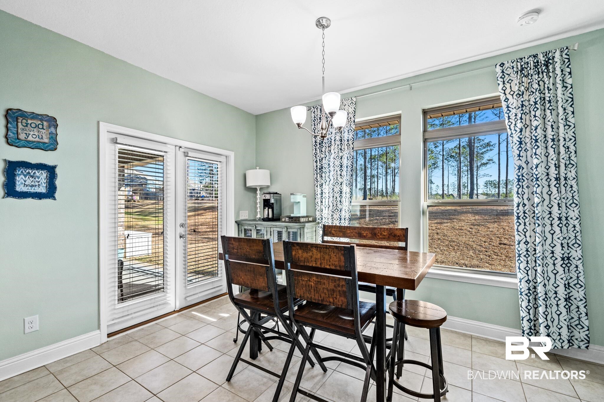 31472 Hoot Owl Road Daphne, AL 36527 - Photo 12 of 32 Dining area with light tile patterned floors, an inviting chandelier, and a healthy amount of sunlight