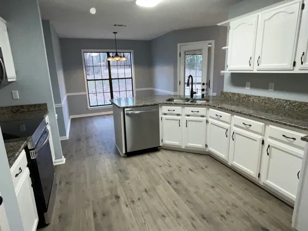 a kitchen with granite countertop a stove a sink and a microwave