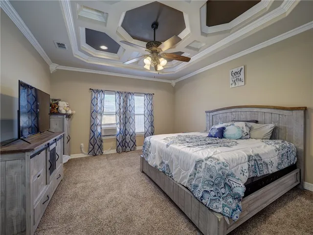 a spacious bedroom with a bed and a flat tv screen on dresser