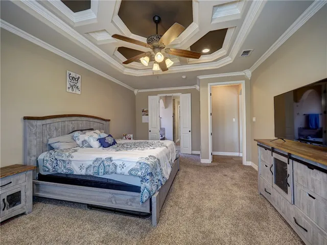 a spacious bedroom with a bed and a flat tv screen on dresser