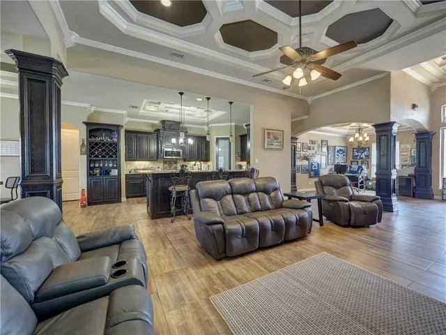 a living room with furniture kitchen and a chandelier