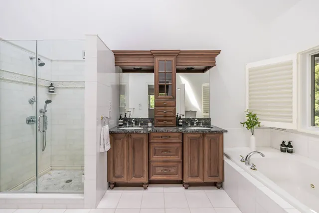 a bathroom with a granite countertop sink a bathtub and shower