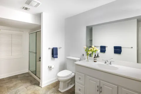 a bathroom with a sink a toilet and shower