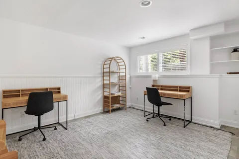 a view of a workspace with furniture and a window