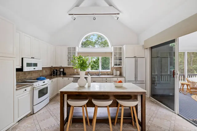 a kitchen with a dining table chairs and window