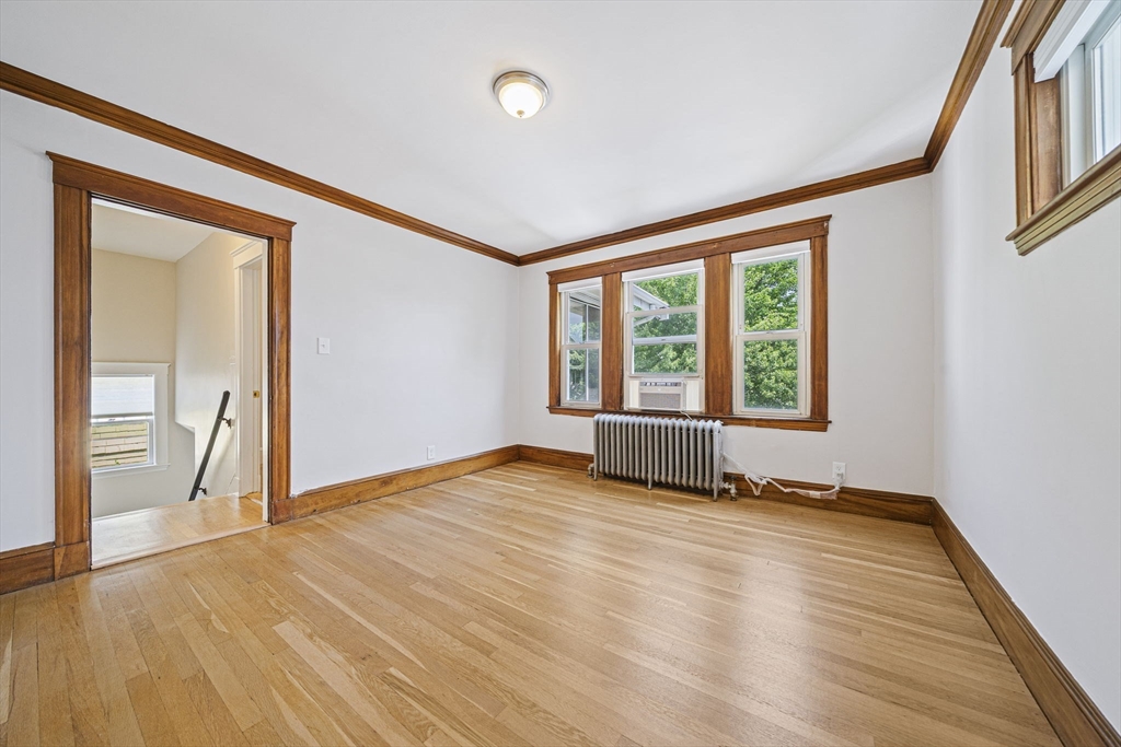 104 Greaton Road, Unit 2 Boston, MA 02132 - Photo 9 of 32 a view of an empty room with glass door and a window