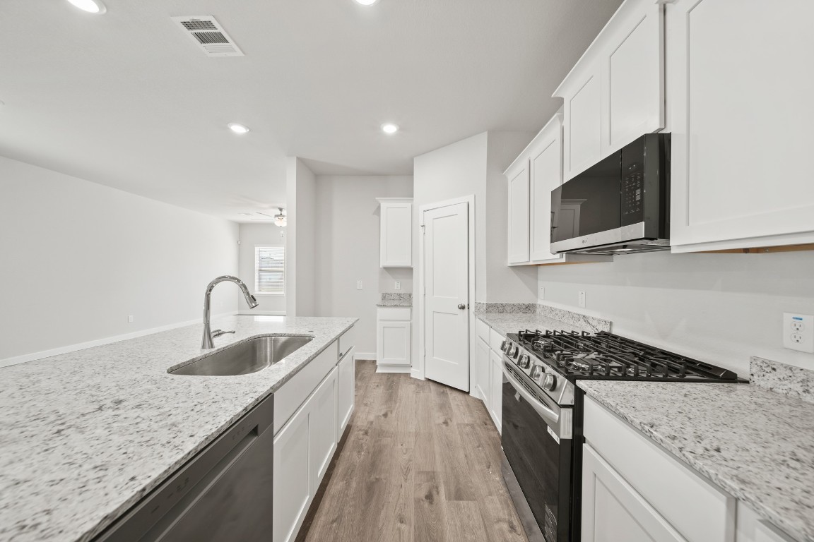 314 Amy Street Angleton, TX 77515 - Photo 9 of 31 a kitchen with stainless steel appliances granite countertop a sink stove and microwave