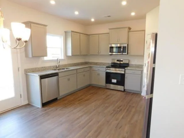 a kitchen with stainless steel appliances granite countertop a sink stove and refrigerator