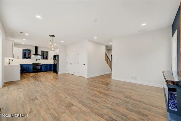 a kitchen with stainless steel appliances a refrigerator and a wooden floor
