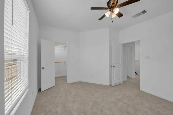 a view of a room with closet and a ceiling fan