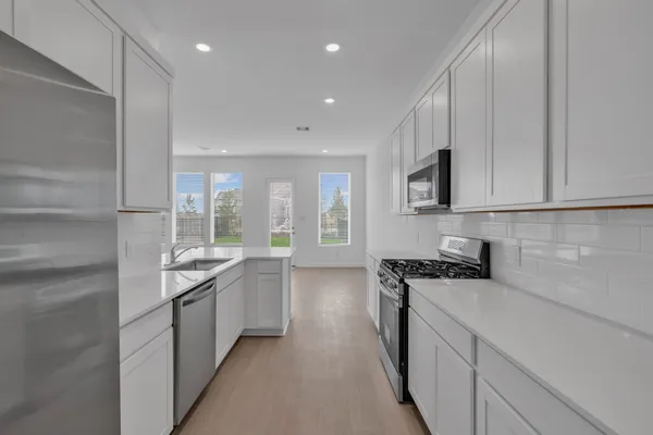 a kitchen with stainless steel appliances granite countertop a stove a sink and a refrigerator