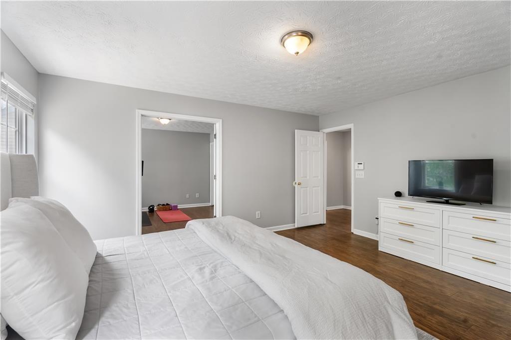 411 Sugar Maple Court Canton, GA 30114 - Photo 19 of 34 a bedroom with a bed and flat screen tv
