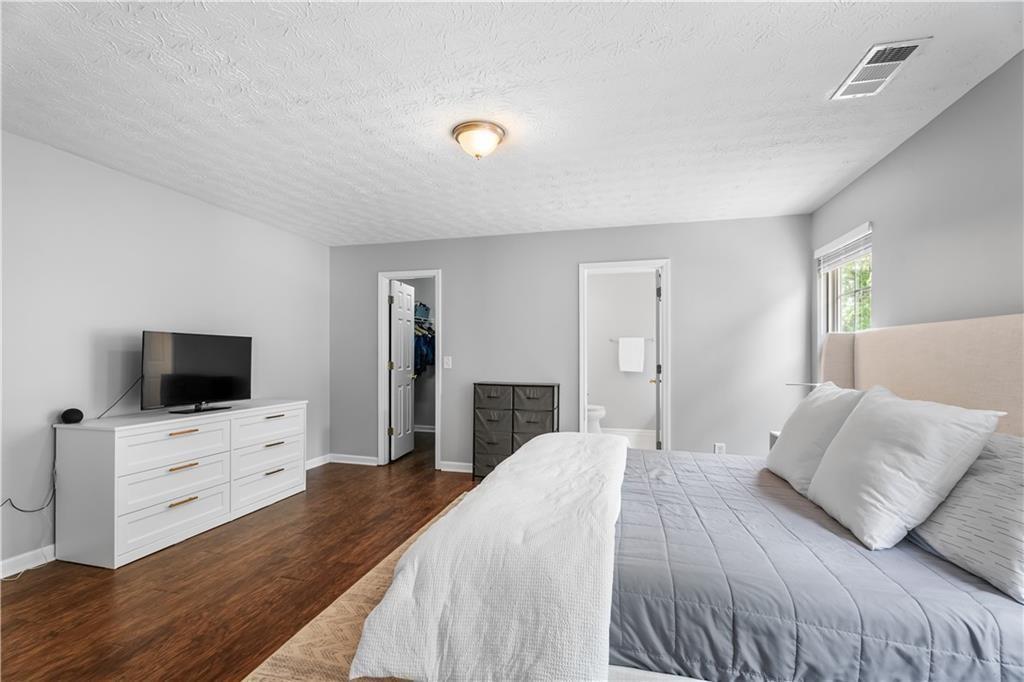 411 Sugar Maple Court Canton, GA 30114 - Photo 20 of 34 a bedroom with a bed and a flat screen tv