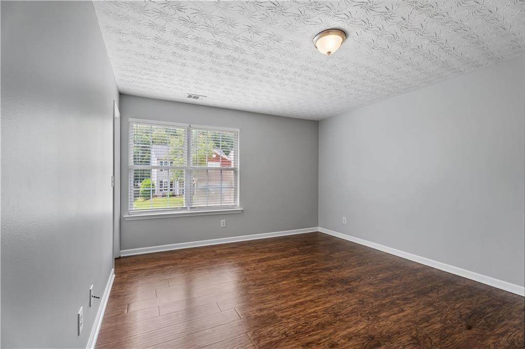 411 Sugar Maple Court Canton, GA 30114 - Photo 24 of 34 an empty room with wooden floor and windows
