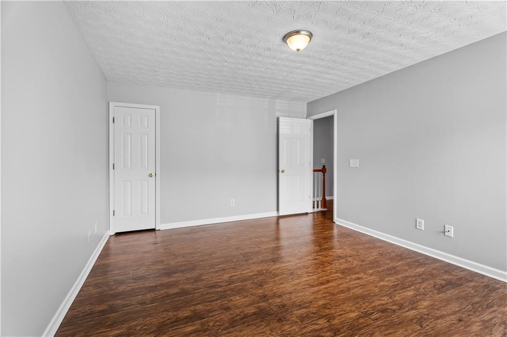 411 Sugar Maple Court Canton, GA 30114 - Photo 25 of 34 an empty room with wooden floor and natural light