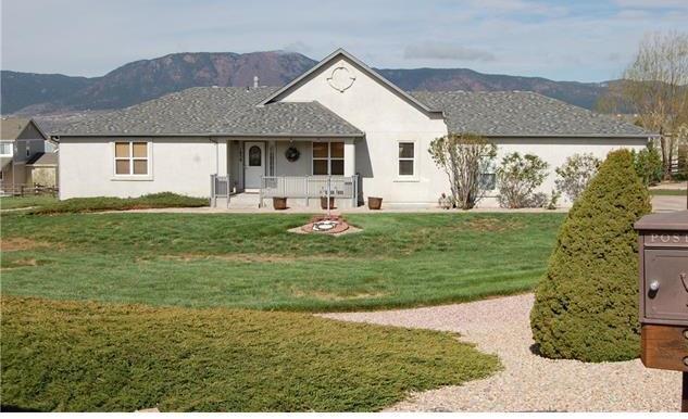 1038 Bowstring Road Monument, CO 80132 - Photo 1 of 25 a front view of a house with a garden and yard