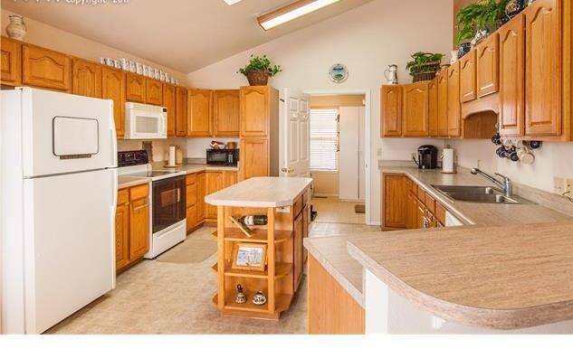 1038 Bowstring Road Monument, CO 80132 - Photo 7 of 25 a kitchen with stainless steel appliances granite countertop a sink a stove and a refrigerator