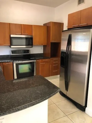 a kitchen with stainless steel appliances granite countertop a sink stove and microwave