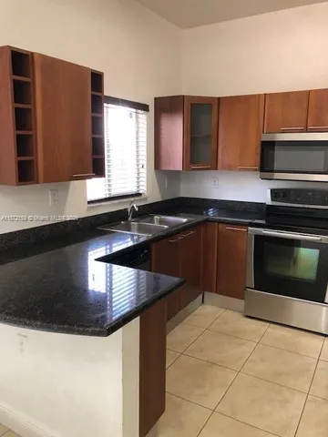 a kitchen with granite countertop cabinets and window
