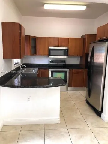 a kitchen with stainless steel appliances a sink and a refrigerator
