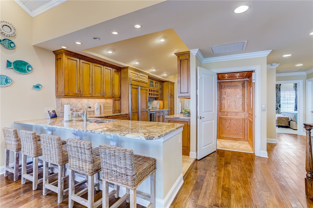 2384 South Fletcher Avenue Fernandina Beach, FL 32034 - Photo 11 of 35 a kitchen with granite countertop kitchen island stainless steel appliances a sink and a refrigerator