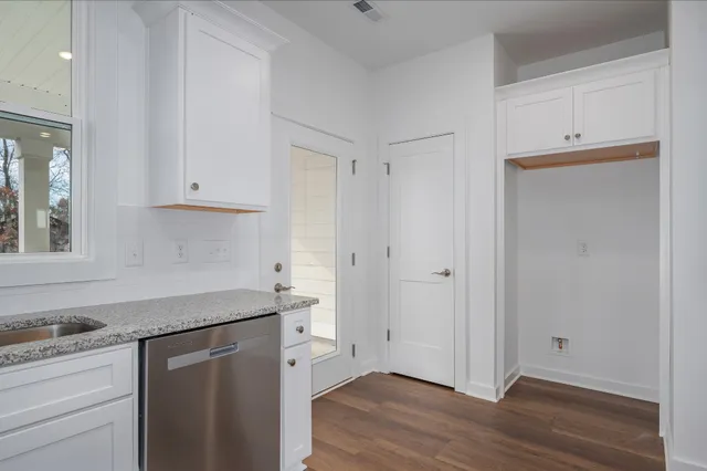 a kitchen with a sink cabinets and wooden floor