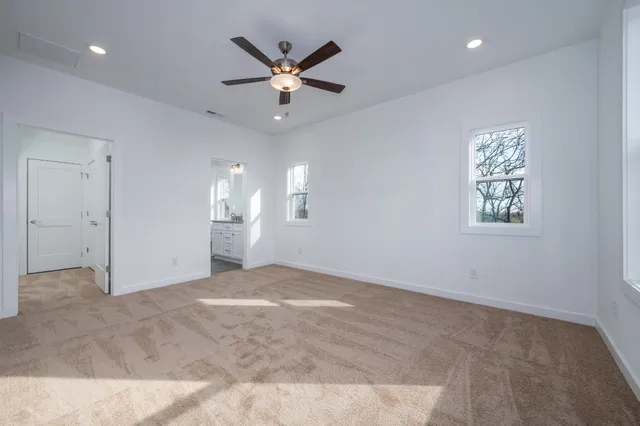 an empty room with fan and windows