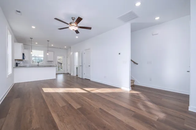 a view of a kitchen with a sink and dishwasher a refrigerator with wooden floor