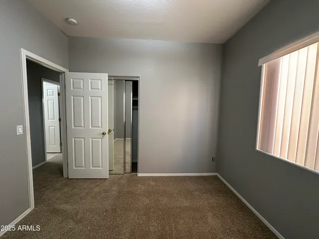 an empty room with windows and closet