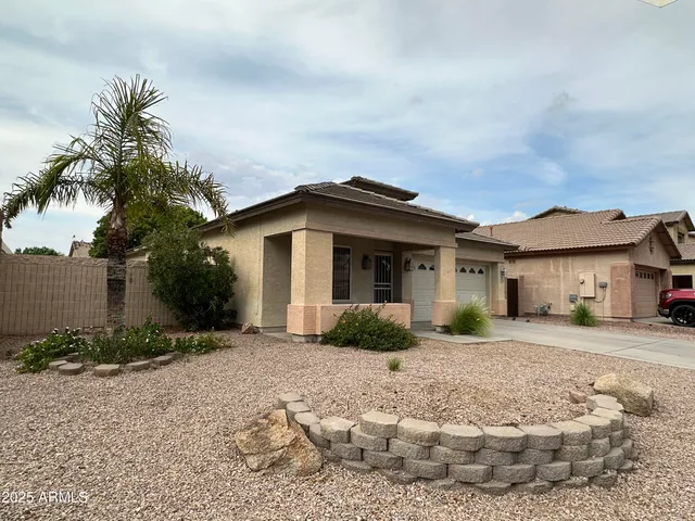 a front view of a house with a yard and potted plants