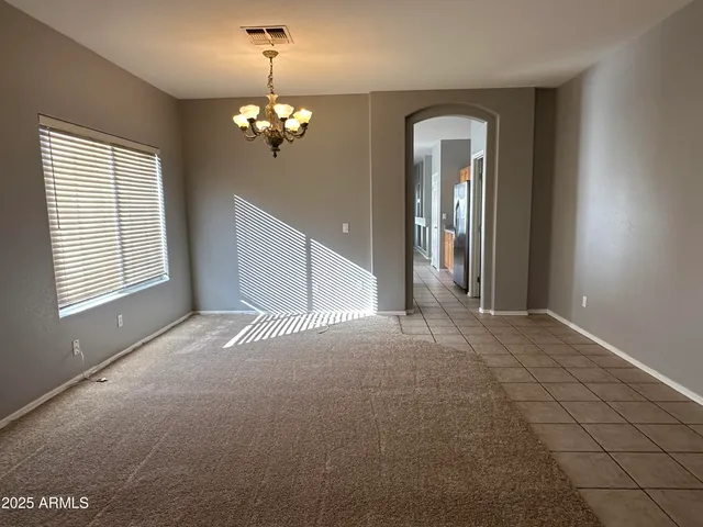 a view of a livingroom with a chandelier fan and windows