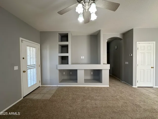 a view of an empty room with a fireplace and a window