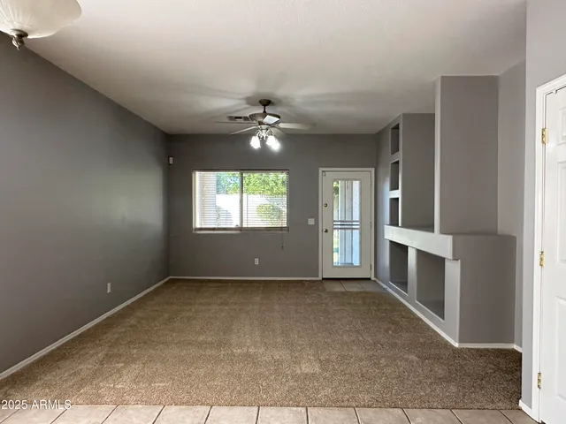 a view of an empty room with a fireplace and a window
