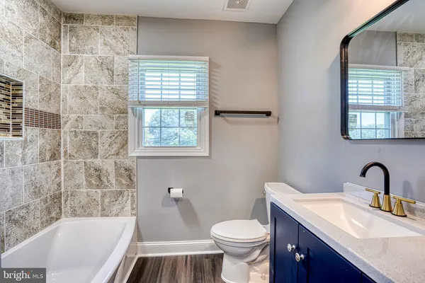 an empty room with wooden floor closet and windows