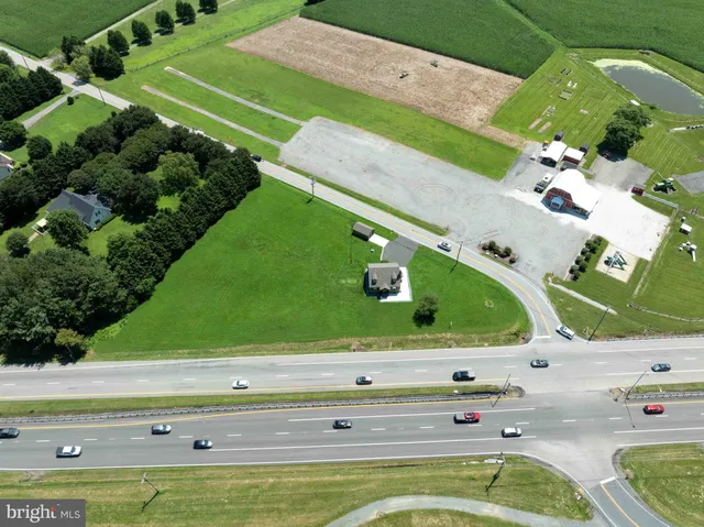 an empty room with wooden floor a fireplace and a window