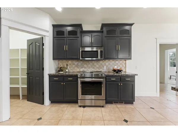 a kitchen with stainless steel appliances kitchen island granite countertop a stove and a refrigerator