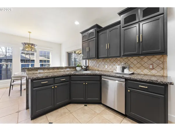a kitchen with granite countertop a sink cabinets and stainless steel appliances