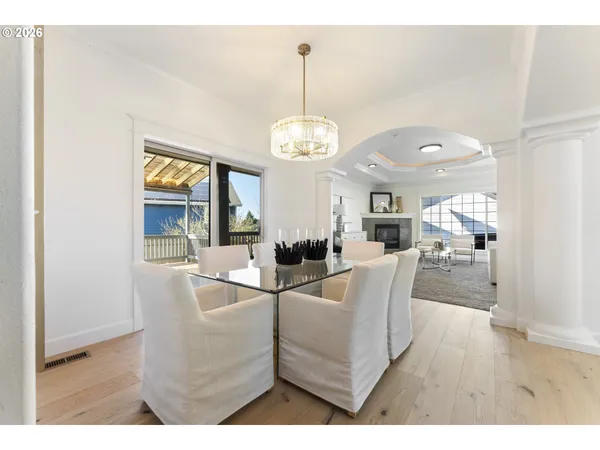 a view of a dining room with furniture a chandelier and wooden floor