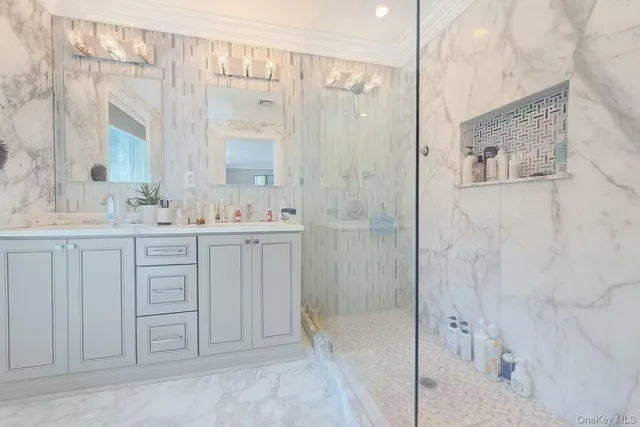 a bathroom with a double vanity sink a large mirror and shower