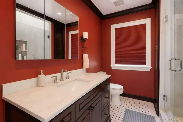 a bathroom with a sink a toilet and a mirror