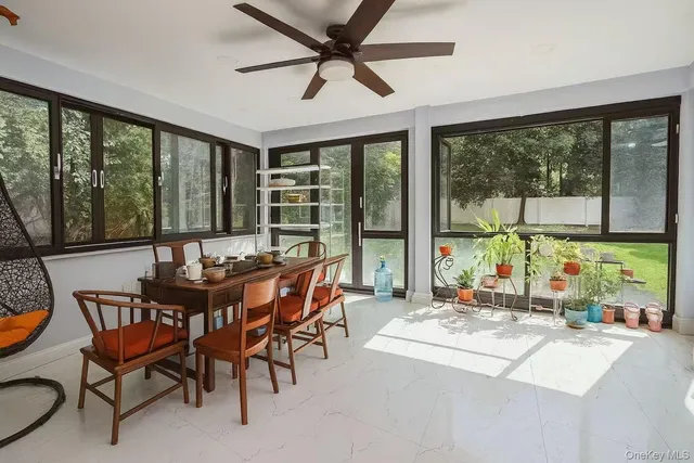 a dining room with furniture a chandelier and a floor to ceiling window