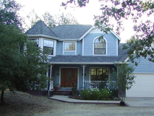 8277 Placer Road Redding, CA 96001 - Photo 1 of 9 a front view of a house with garden