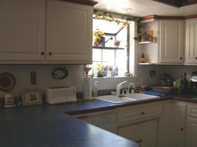 8277 Placer Road Redding, CA 96001 - Photo 5 of 9 a kitchen with a sink a stove a window and cabinets
